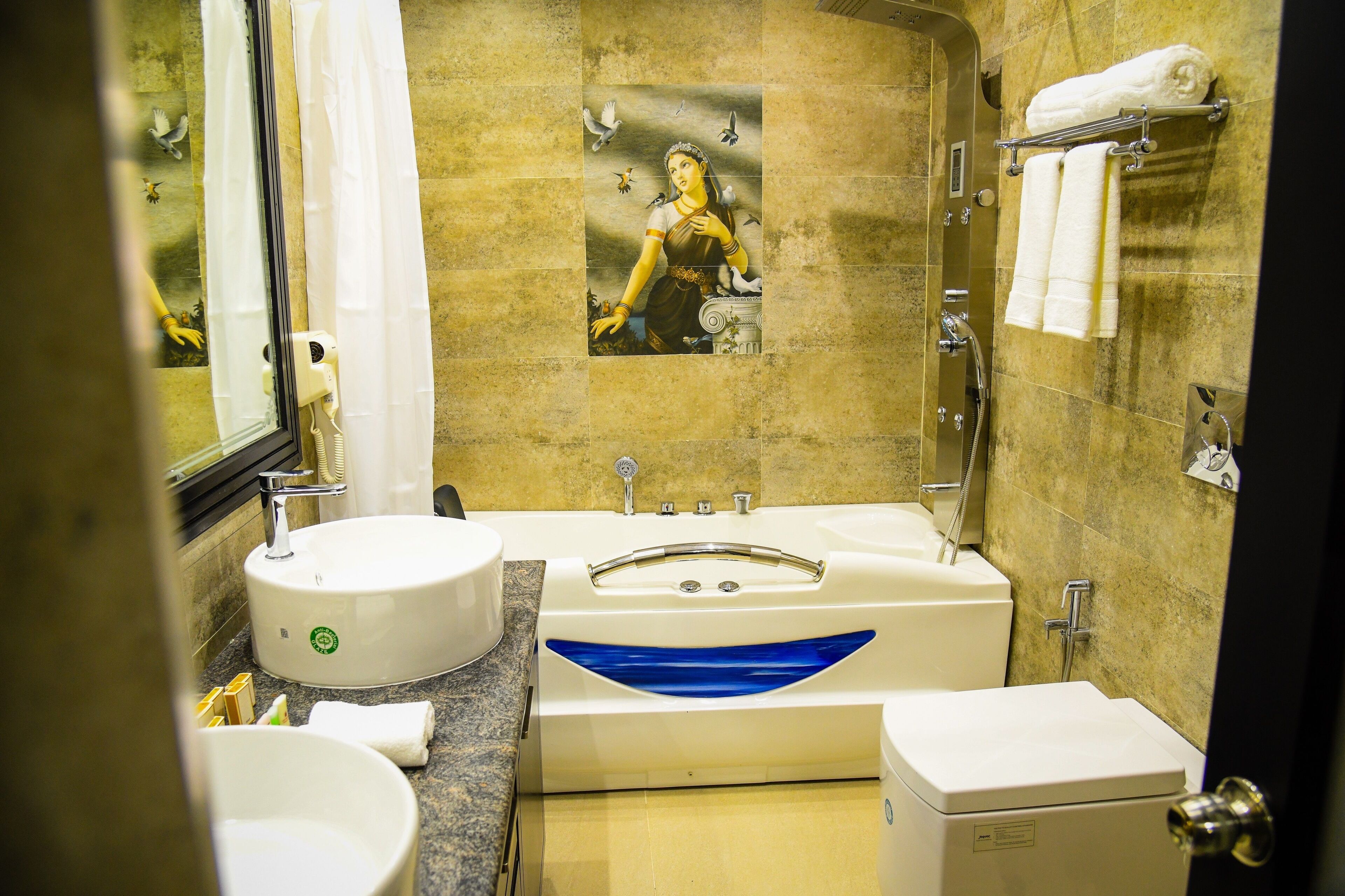 A bathroom with a bathtub, a sink, and a toilet. There is a towel rack with towels on it.