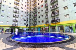En flervåningsbostadsbyggnad med en centralt placerad swimmingpool.