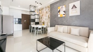 Een moderne woonkamer met een bank, een salontafel en een eethoek met stoelen en een tafel.