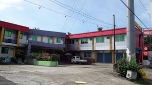 A multi-story building with a parking area in front. - Princess Perrine Suites (Davao)