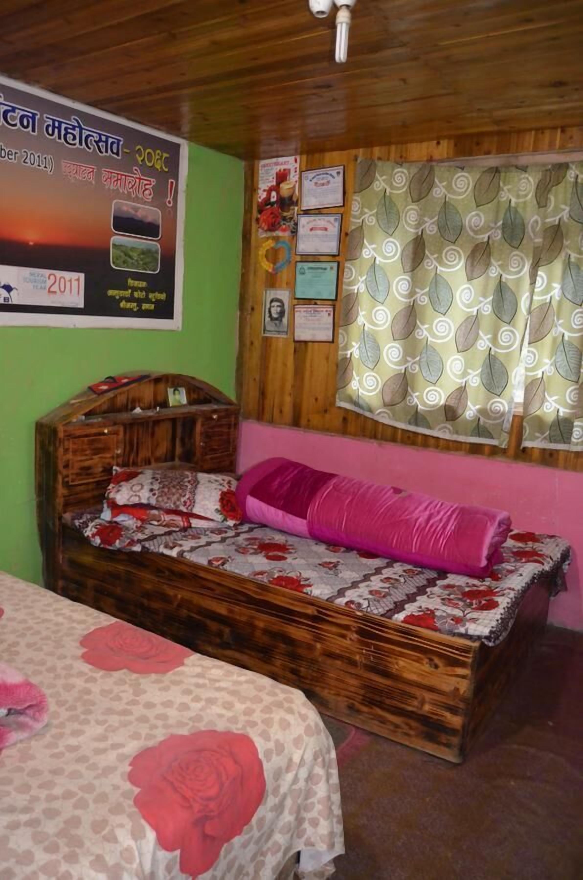 Una habitación con una cama de madera, una pared verde y un cartel.