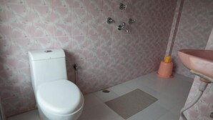 Un baño con inodoro, lavabo y ducha.