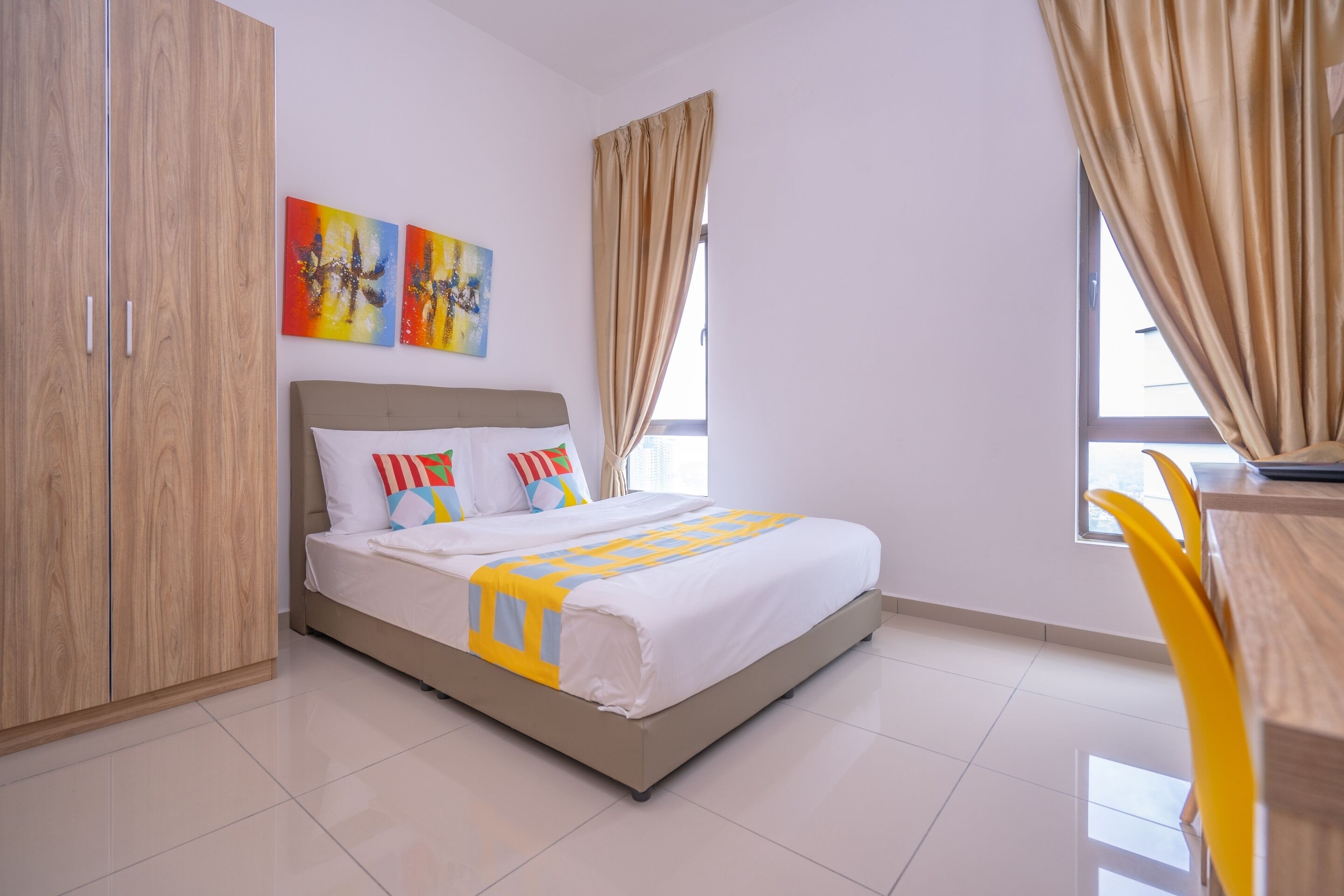 Un dormitorio con cama, armario, escritorio y cortinas.