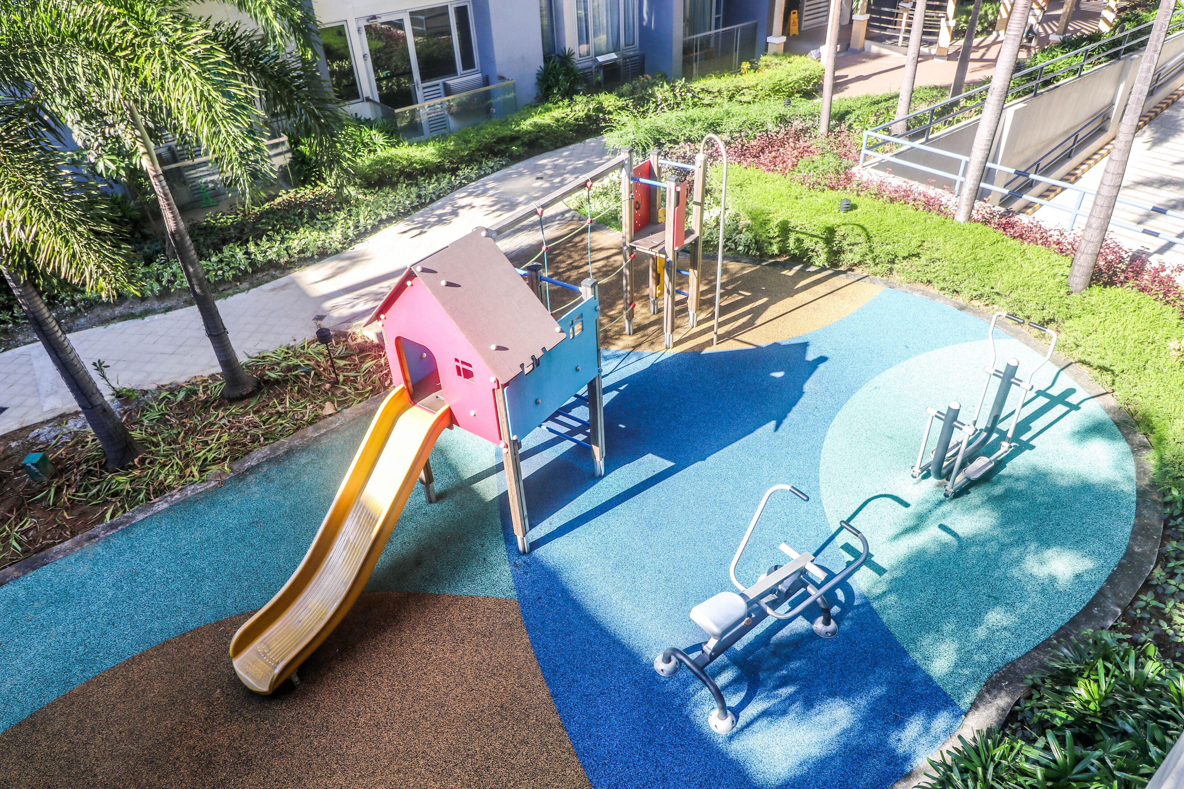 A playground with a slide, climbing structures, and exercise equipment.