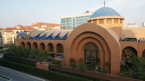 A building with a large dome and arched windows, surrounded by greenery and a road. - PRS @ One Palm Tree Villa near T3 Airport (Pasay)