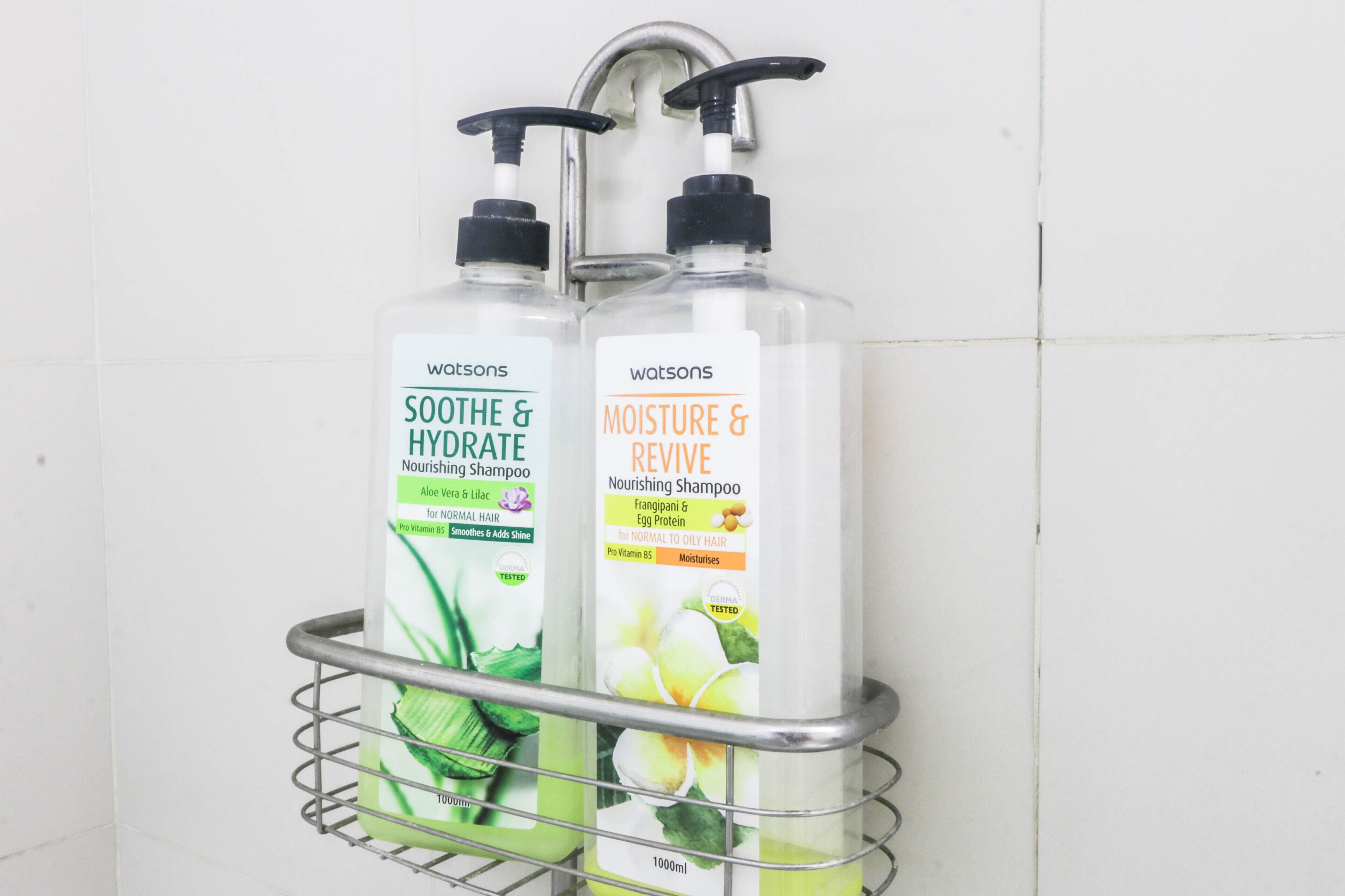 Two bottles of Watsons Nourishing Shampoo in a metal rack.
