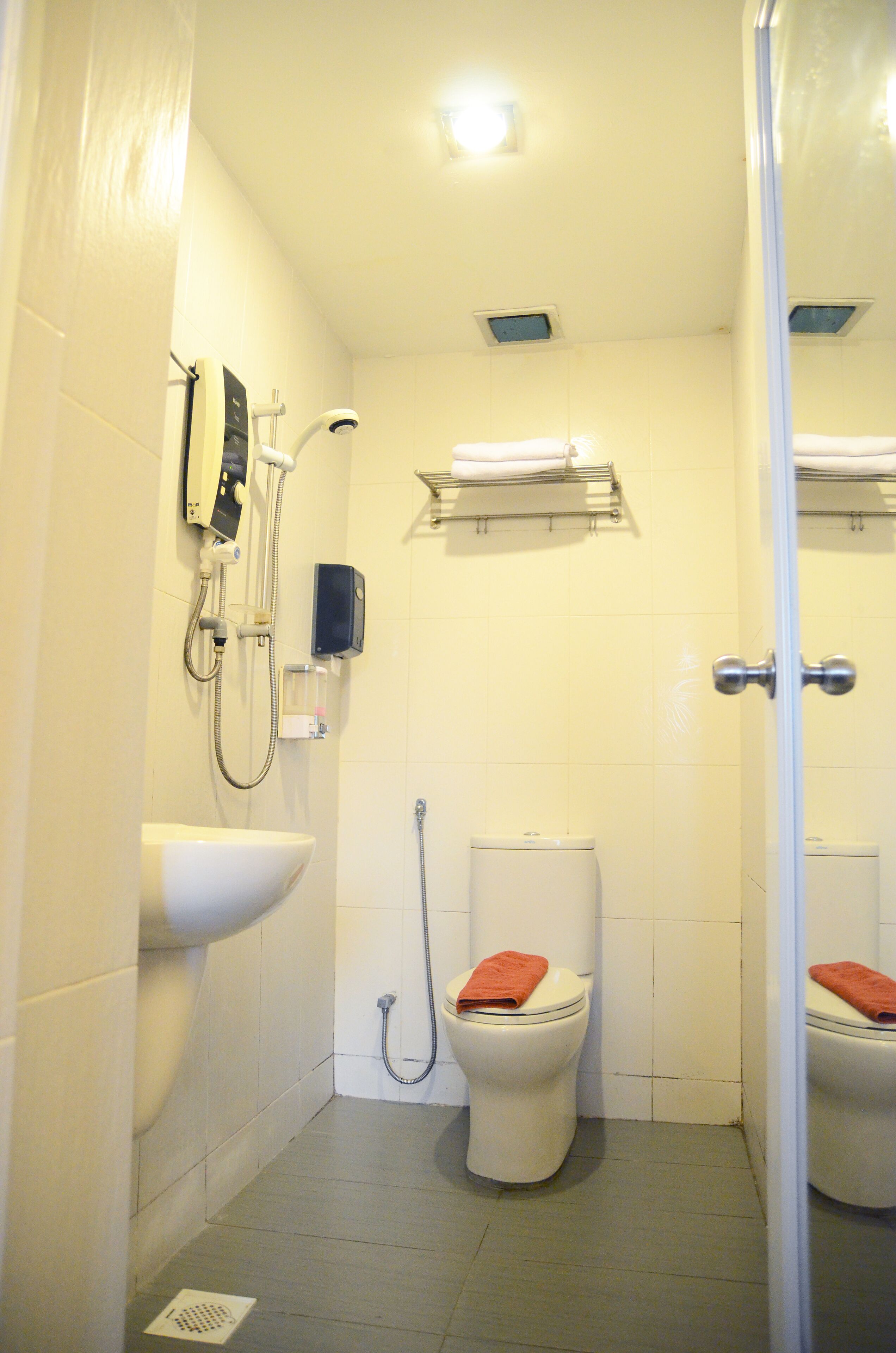 Ein kleines, sauberes Badezimmer mit Toilette, Waschbecken und Dusche.