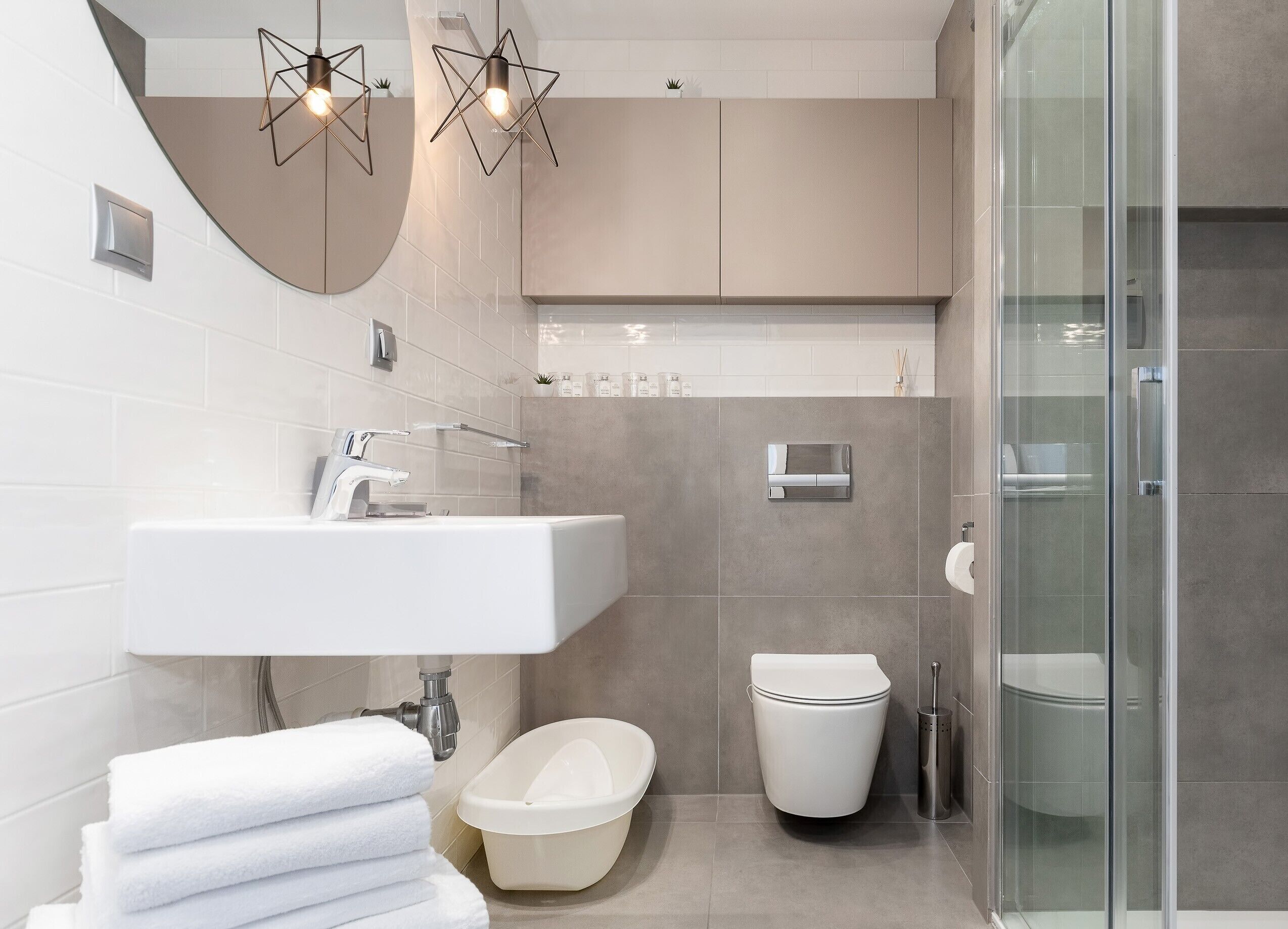 A modern bathroom with a white sink, a freestanding bathtub, and a glass shower enclosure.