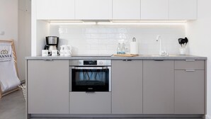 Uma cozinha moderna com forno embutido, cafeteira e geladeira Samsung.