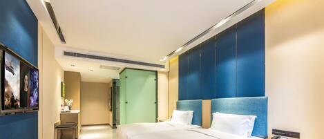A modern hotel room with a large bed, bedside tables, and a view of the hallway.