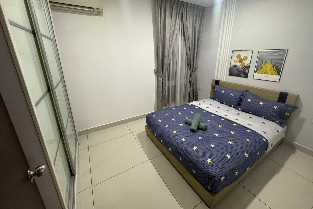 A bedroom with a bed, a ceiling fan, a window with curtains, and a wall-mounted air conditioner.