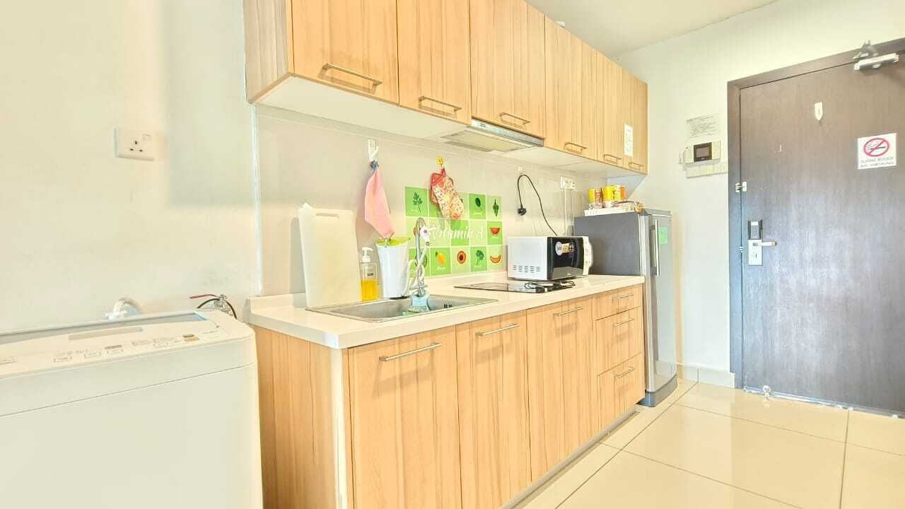 Una cocina con armarios de madera, microondas, fregadero y refrigerador.