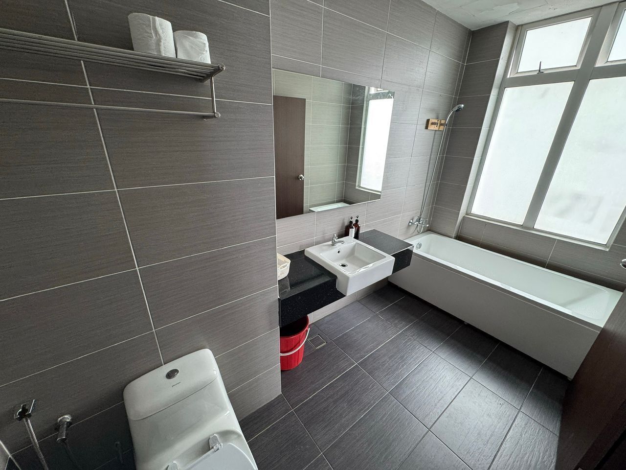 Un baño moderno con bañera, lavamanos e inodoro.
