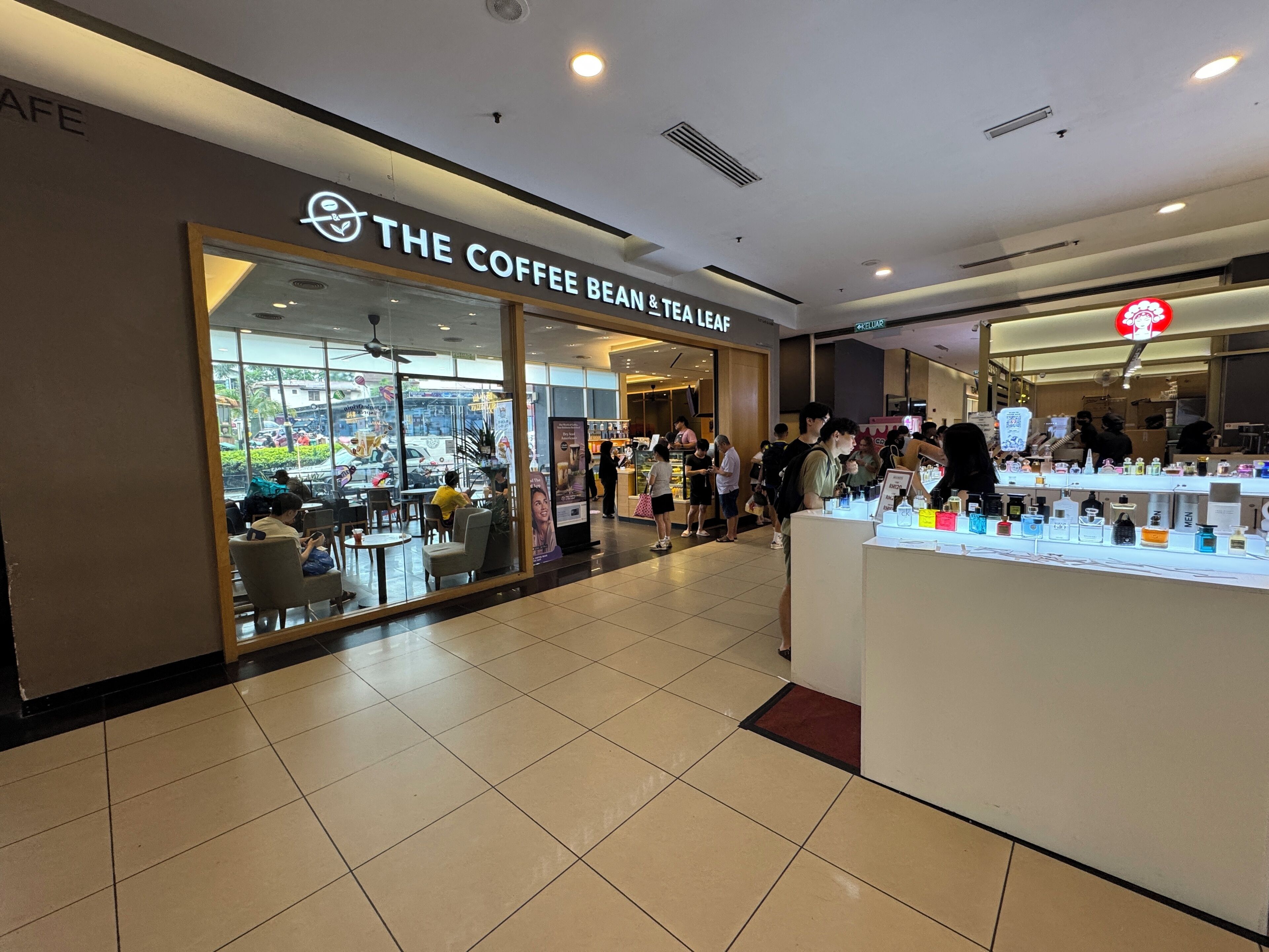 Una cafetería con una decoración moderna, una barra visible con diversos productos y un letrero que indica que es una tienda de café y té.