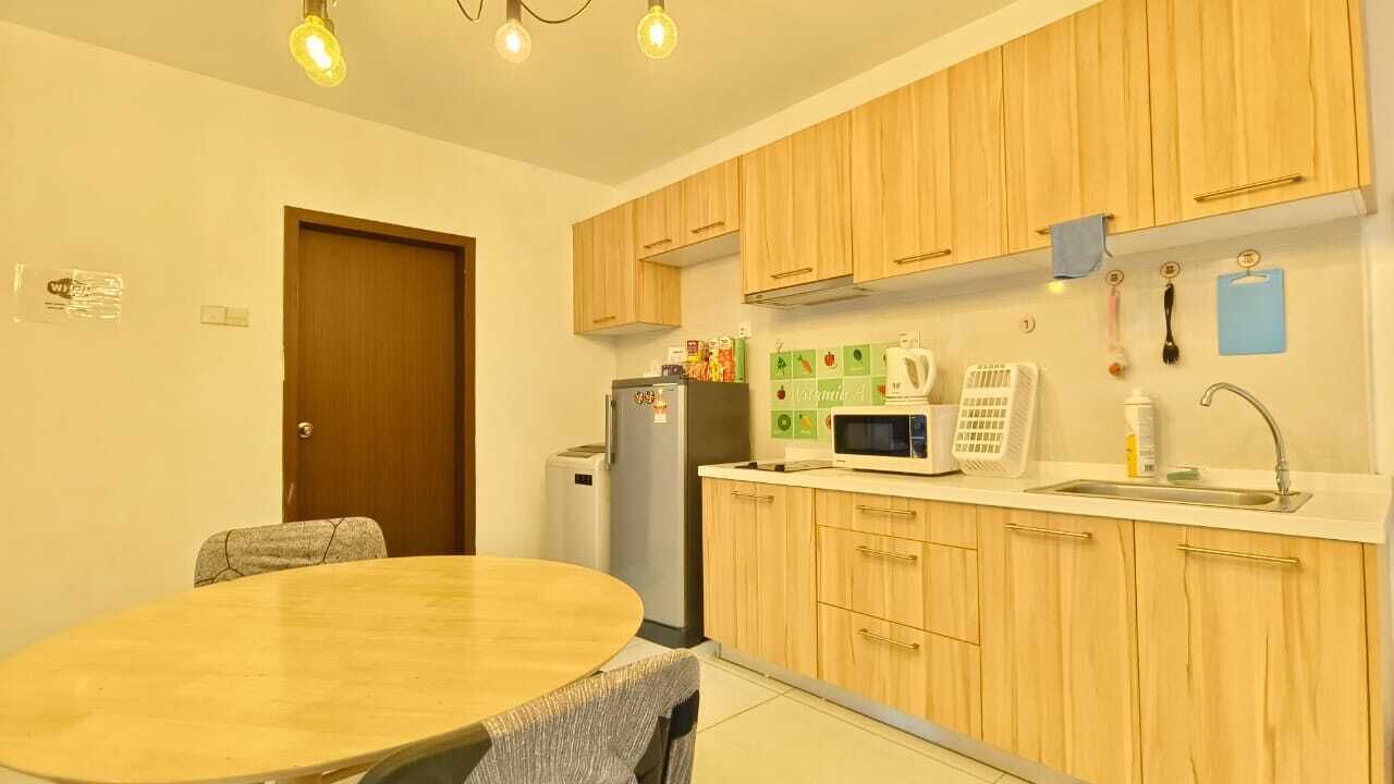 Une cuisine compacte dotée de meubles en bois, d’un four à micro-ondes, d’un réfrigérateur et d’une table à manger avec des chaises.