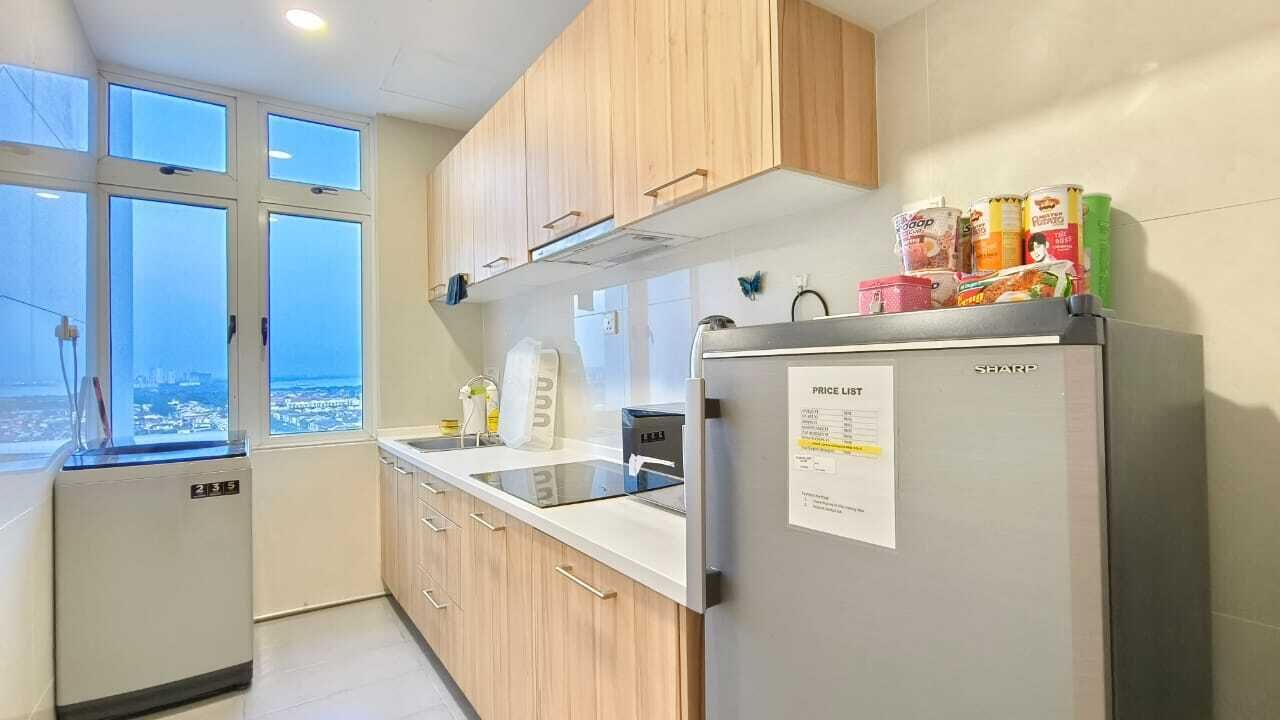Een moderne keuken met houten kastjes, een roestvrijstalen koelkast en een raam met uitzicht op de stad.