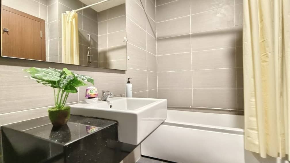 A bathroom with a sink, mirror, and shower.