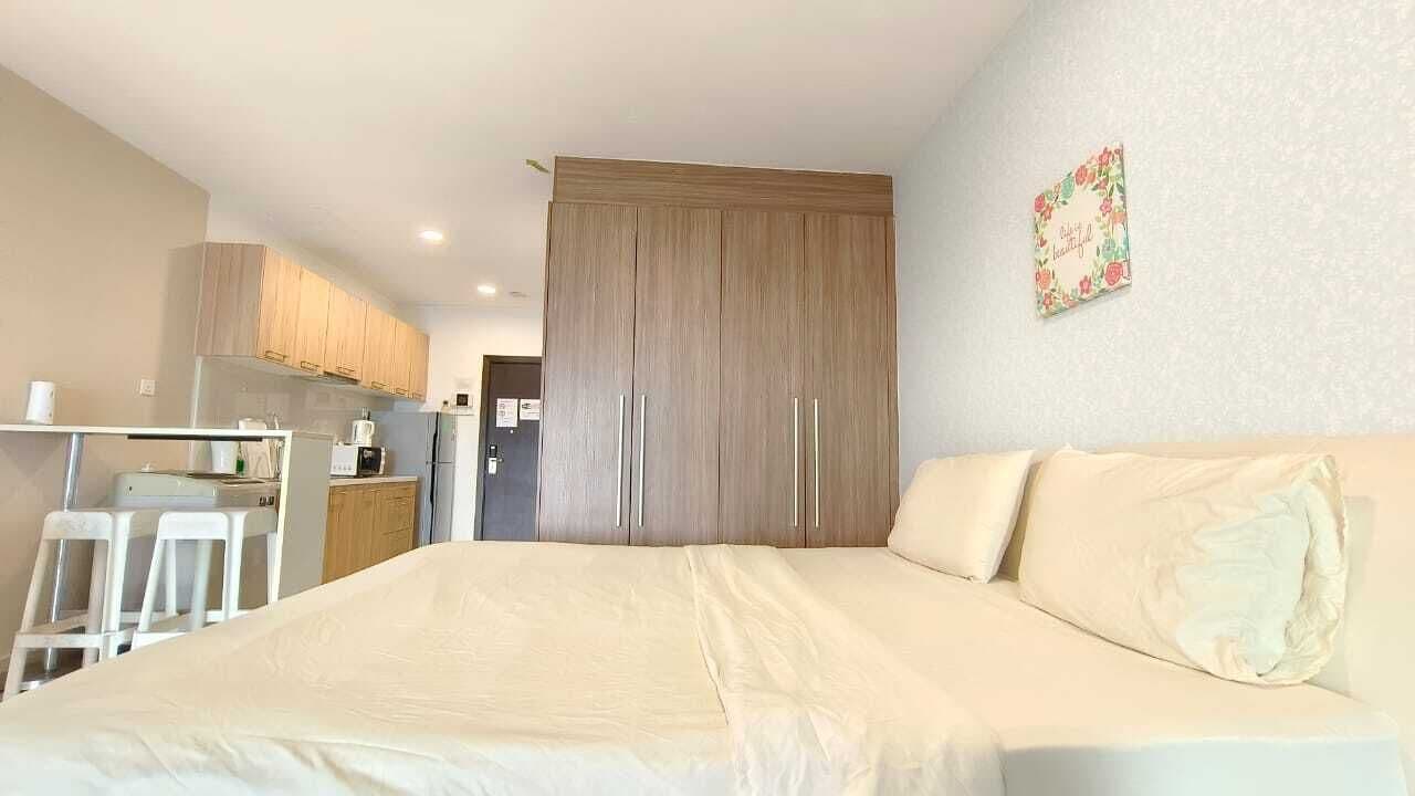 Une chambre comprenant un lit, un coin cuisine et une armoire.
