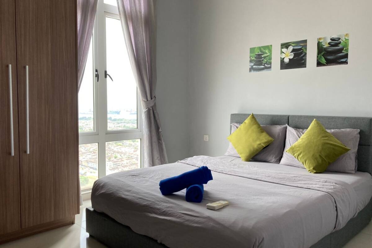 A bedroom with a bed, a wardrobe, and a window with curtains.