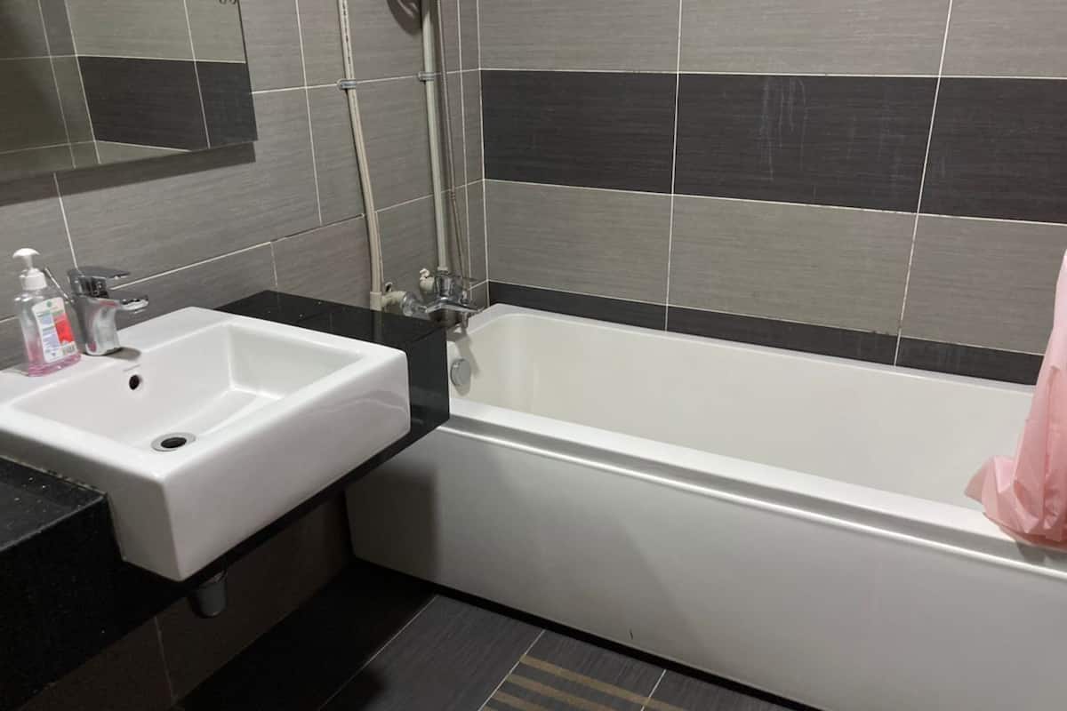 A modern bathroom with a white sink, a bathtub, and a shower.