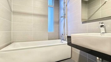 Ein modernes Badezimmer mit freistehender Badewanne, einem Waschbecken und einer Dusche.