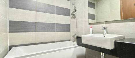 A modern bathroom with a bathtub, a sink, and a shower.
