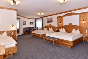 A hotel room with two wooden beds, a small table, and a wooden cabinet. - Hotel Wender (Aurach)