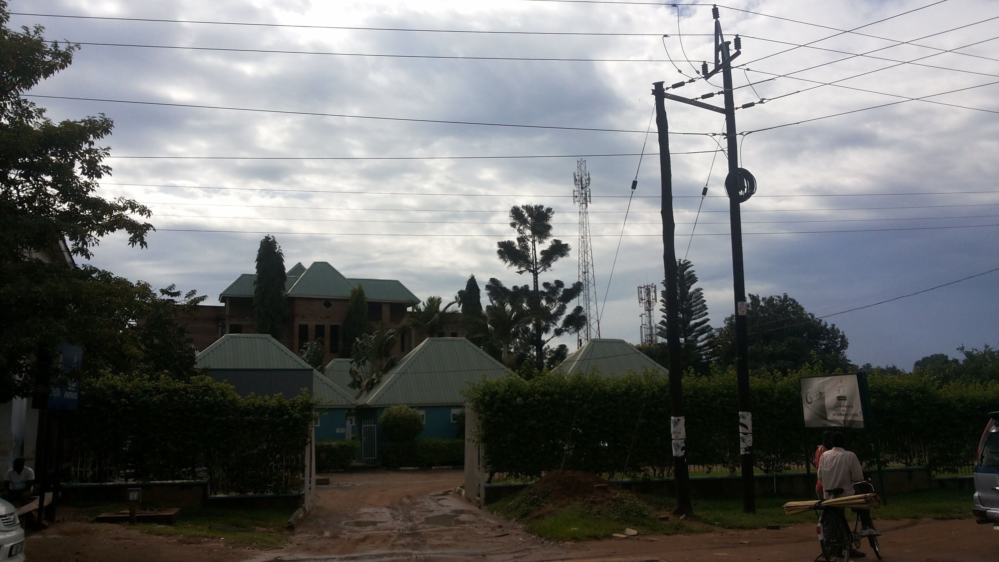 A residential area with houses, a dirt road, and utility poles.