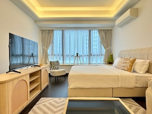 A modern hotel room with a large bed, a TV, a desk, and a window with curtains. - JB City CIQ-R&F Shopping Mall Apartment (Johor Bahru)