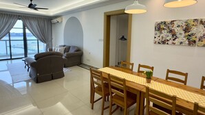 Un salon moderne avec un canapé, une table à manger et des chaises, ainsi qu’un ventilateur de plafond.