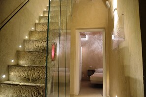 A staircase with stone steps leading to a bedroom with a bed and a television. - Trapani Secret B&B (Trapani)