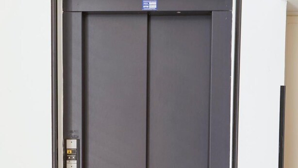 A modern, dark-colored elevator door with a control panel on the left side. - B&B San Francesco (Nicosia)
