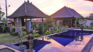 A serene pool area with two traditional-style gazebos, surrounded by lush greenery and a clear sky. - Dream Beach Berlian (Lembongan Island)