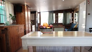 Une cuisine avec un îlot central, des meubles en bois et un saladier rempli de fruits.