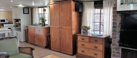 Una habitación acogedora con un armario de madera, una mesa de comedor, un sofá y una chimenea.