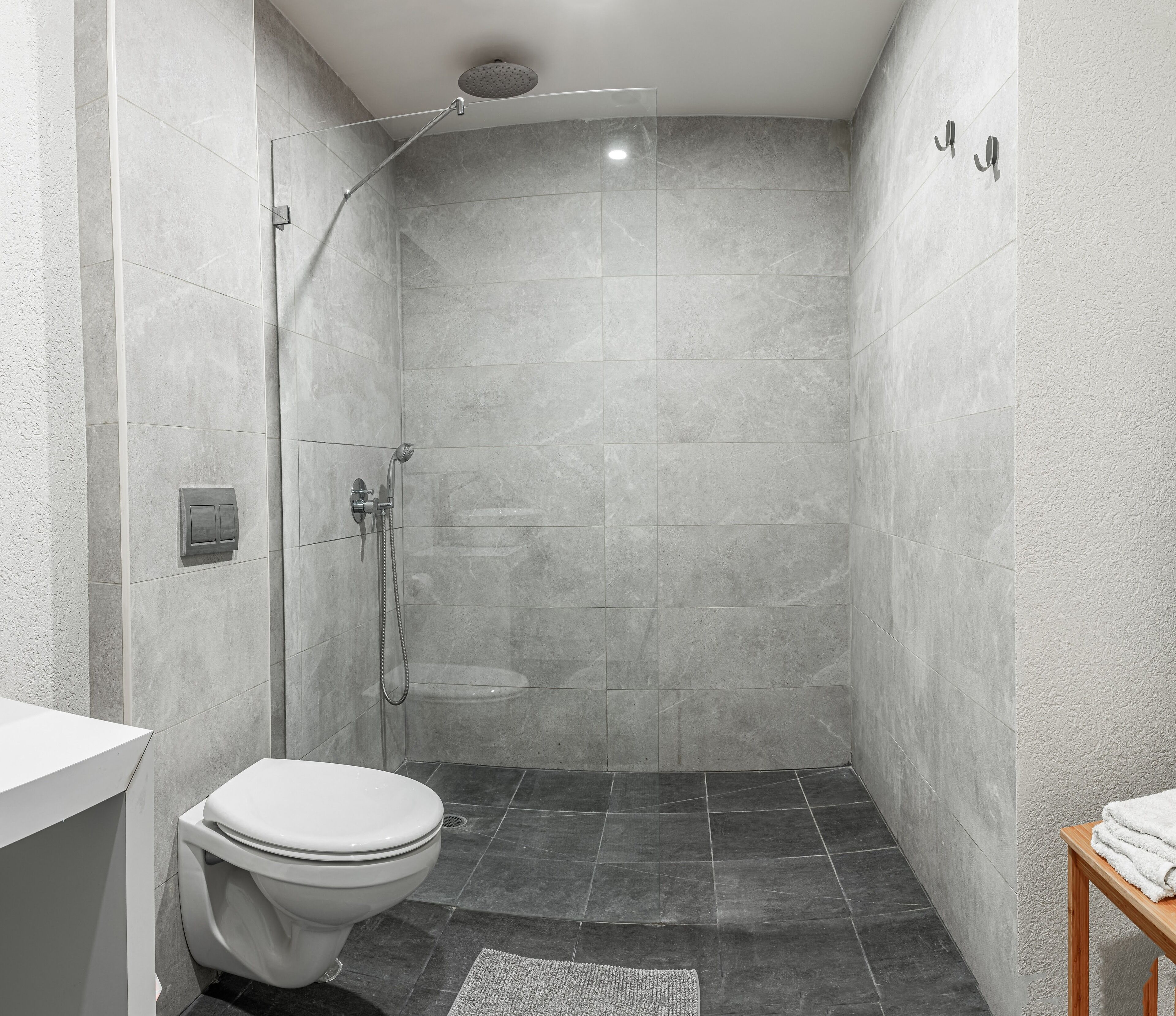 A modern bathroom with a shower, toilet, and sink.