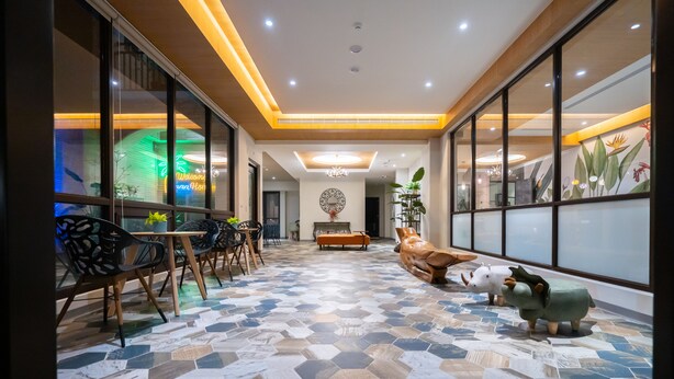 A spacious lobby with a hexagonal patterned floor, a reception desk, seating area, and decorative animal figurines. - Relaxury Beach House (Hengchun)