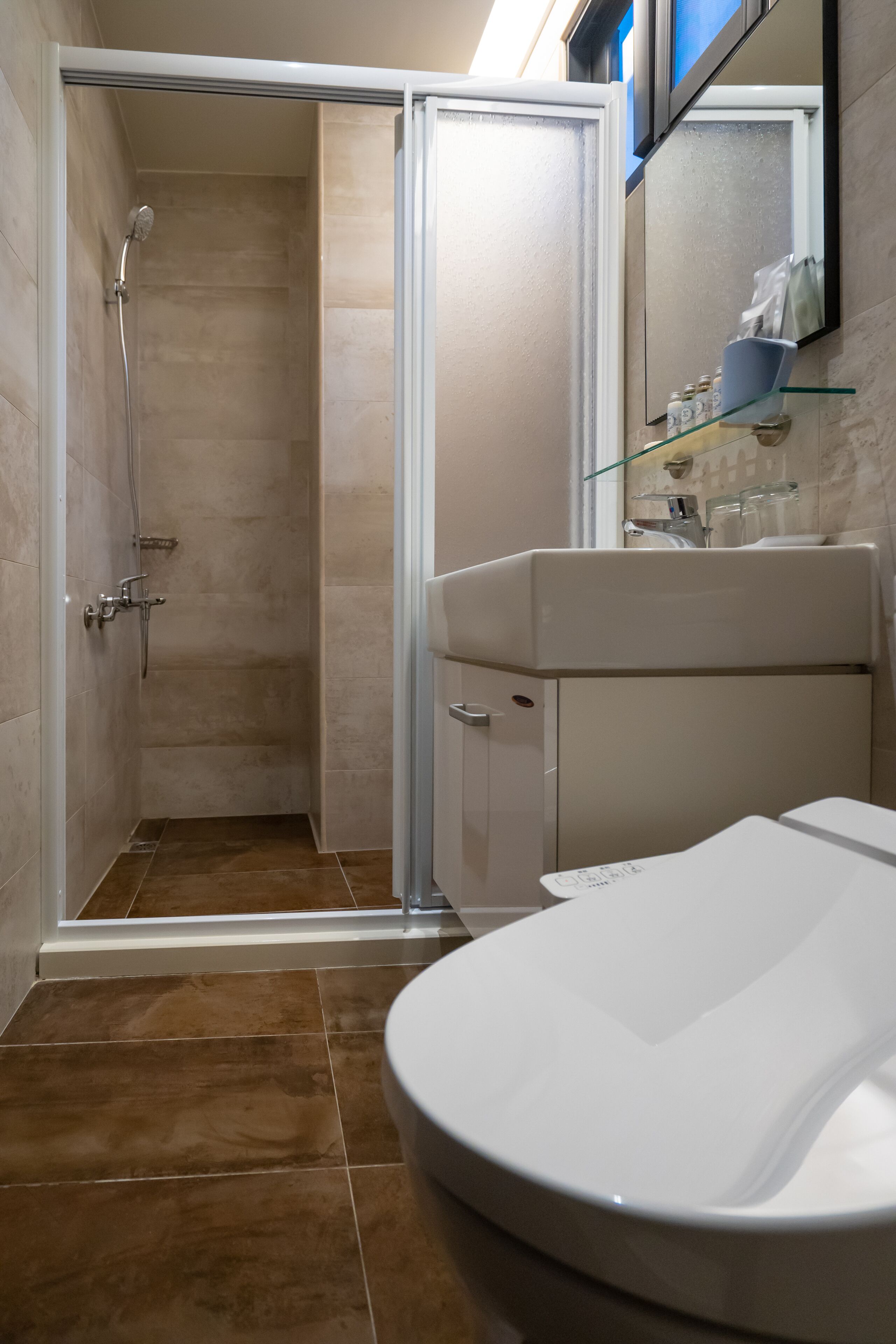 A bathroom with a shower, toilet, and sink.