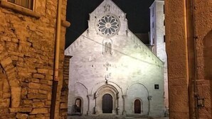 A stone building with a large arched entrance and a circular window above the door. - La Cattedrale B&B (Ruvo di Puglia)