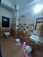 A bathroom with a toilet, sink, shower, and decorative tiles.
