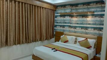 A bedroom with a bed, curtains, a headboard with a decorative panel, and a wall with a wooden plank design.