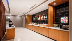 A modern hotel lobby with a long reception desk, wooden paneling, and a digital menu display. - SpringHill Suites by Marriott Denver Parker (Parker)