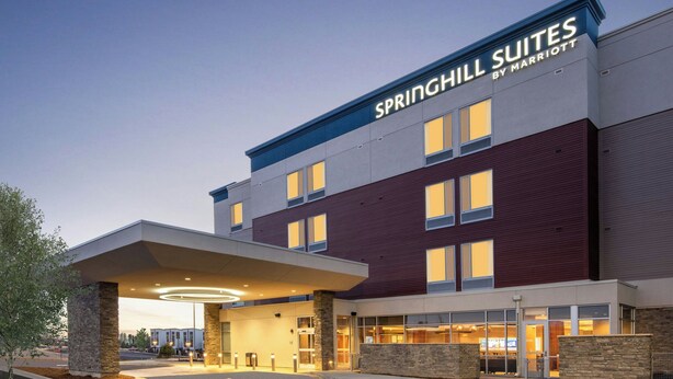 A modern hotel with a prominent signage for Springhill Suites by Marriott. It features a covered entrance, a stone facade, and a well-lit interior visible through the windows. - SpringHill Suites by Marriott Denver Parker (Parker)