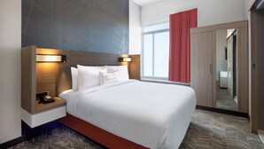 A hotel room with a large bed, bedside tables, a mirror, and a wardrobe. - SpringHill Suites by Marriott Denver Parker (Parker)
