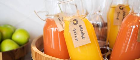 Una cesta de madera con varias botellas de vidrio que llevan etiquetas, presumiblemente con bebidas.