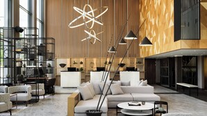 Un hall d’entrée moderne avec un grand canapé d’angle, une table basse et un luminaire géométrique original.