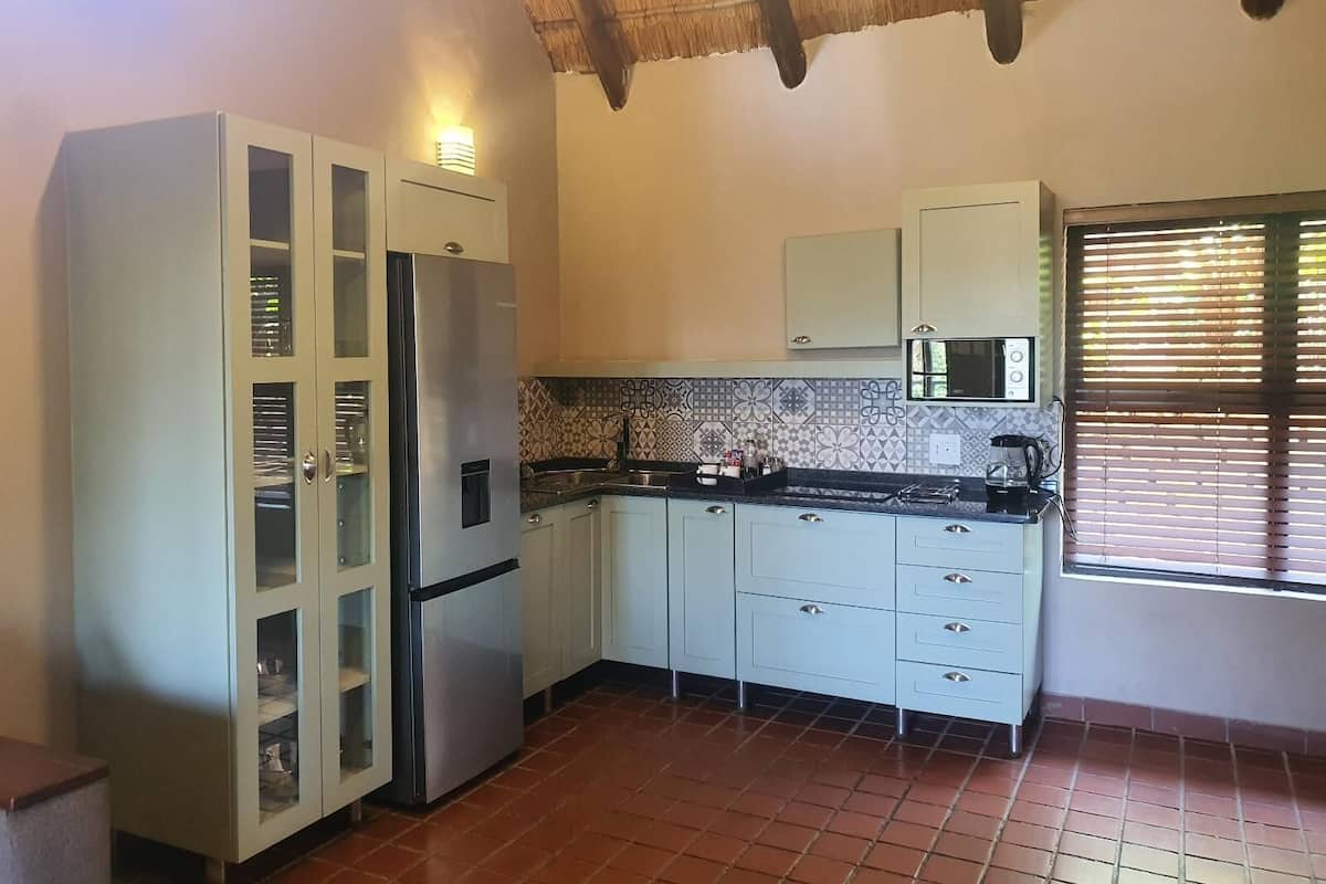 A compact kitchen with a refrigerator, stove, and cabinets.