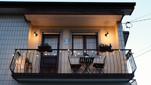 A residential building with a balcony featuring two windows, a door, and a small table with chairs. - Flower House 🏡🌻 (Santo Tirso)