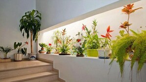 Una escalera con macetas y flores en el rellano.