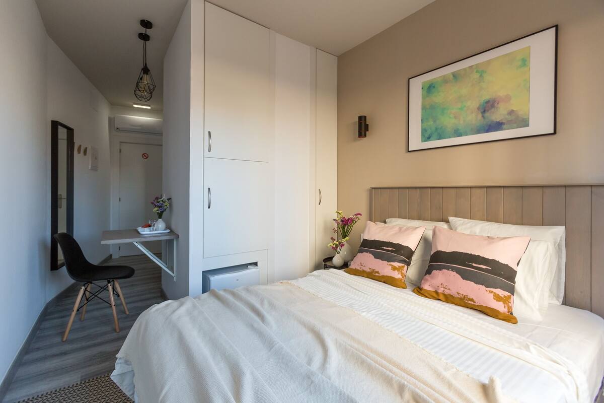 Une chambre moderne avec un grand lit, un bureau et une chaise.